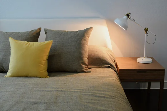Gemachtes Bett mit Leselampe auf Nachttisch